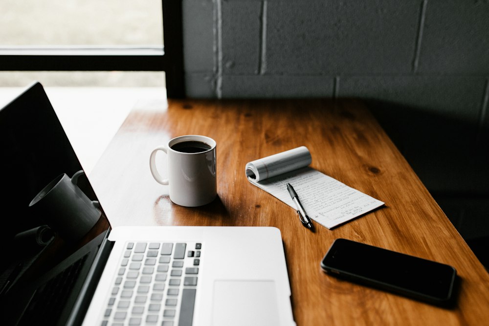 Workspace with laptop, notebook, coffee cup and phone
